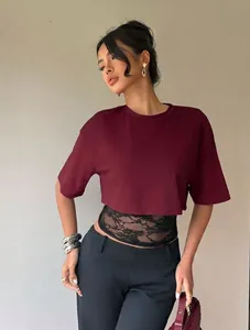 Close-up of burgundy crop top with black lace patchwork on a model for summer fashion
