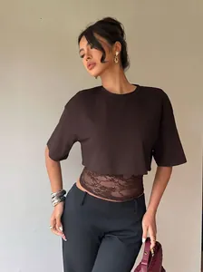 Detail shot of a stylish dark brown crop T-shirt with sheer lace paneling on the waist