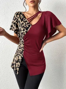Detail view of women's asymmetrical leopard print patchwork top with butterfly sleeves