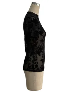 Detailed side view of an elegant black mesh T-shirt with floral flocking pattern