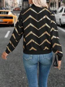 Women's black bomber jacket with gold zigzag print and ribbed cuffs in street setting