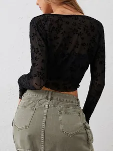 Vista trasera de un top de malla negra transparente con elegante textura floral flocada