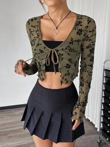 Detalle de top de malla verde transparente con flores negras flocadas y lazo frontal