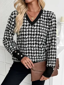 Dettaglio di un elegante top da donna con scollo a V e motivo pied-de-poule nero