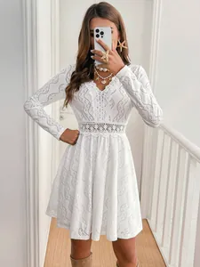 Detailed view of elegant white lace patchwork mini resort dress with scallop hem.