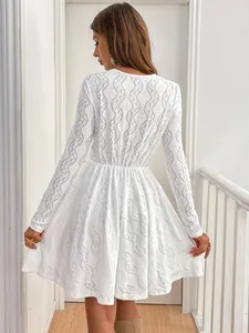 Detailed back view of an elegant white lace mini dress with delicate eyelet patterns