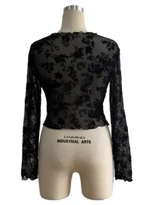 Vue arrière d'un haut noir en maille avec des motifs de dentelle florale complexes.