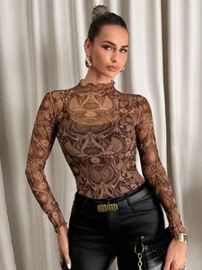 Detalle de top de malla con estampado de cachemira y cuello alto festoneado