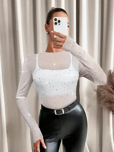 Detailed view of white sheer mesh long sleeve top with sparkling rhinestone accents