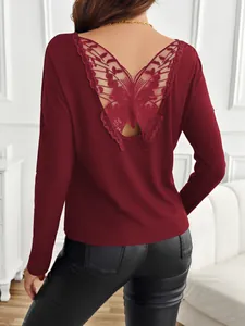 Detailed view of the butterfly lace appliqué on the back of this burgundy ribbed top.