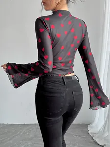 Dettaglio posteriore di maglia in rete nera a maniche lunghe con cuori rossi e maniche svasate