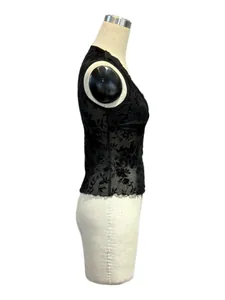 Detalle lateral de un top de malla negra con flores flocadas y cuello en V sobre un maniquí