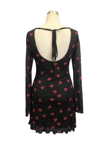 Vue détaillée du dos d'une robe en résille noire avec des motifs de cœurs rouges et nœud