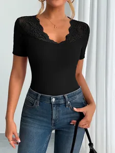 Close-up detail of a black short-sleeved top featuring delicate lace trim at the neckline