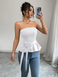 Detail view of white strapless peplum top featuring a large 3D fabric flower.
