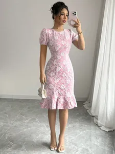 Detail view of a pink floral jacquard slim fit midi dress with ruffled hem.