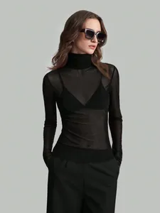 Elegant sheer black mesh turtleneck top styled on a female model with sunglasses