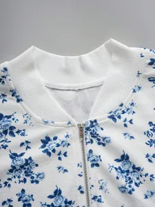 Stylish women's white jacket featuring blue floral print, baseball collar, and zipper