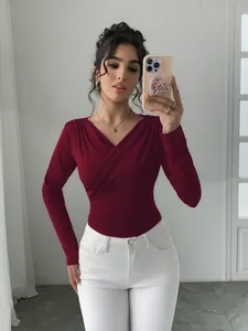 Dettaglio di un top a maniche lunghe bordeaux con scollo a V incrociato su modella