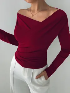 Dettaglio di top a maniche lunghe bordeaux con elegante scollo a V incrociato alla moda.