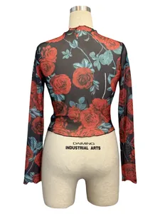Close-up detail of the vibrant red rose floral print on a sheer black mesh long sleeve top.