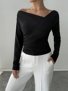 Dettaglio dell'elegante top a portafoglio nero con spalle scoperte e maniche lunghe attillate