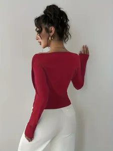 Vista posteriore di un elegante top rosso a maniche lunghe con spalle scoperte e pantaloni