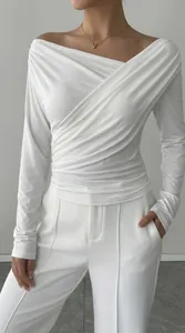Dettaglio di un top bianco a maniche lunghe con elegante design a pieghe incrociate