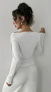 Elegante vista posteriore di un top bianco aderente a maniche lunghe con spalle scoperte