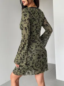 Rear view of olive green mesh dress with black floral flocking and bell sleeves