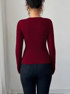 Back view of a slim fit burgundy long sleeve top paired with black skinny pants.