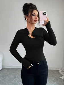 Detail showing the asymmetrical cutout and golden ring on the black slim fit top