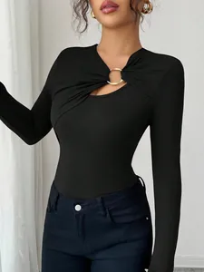 Detail of asymmetrical hollow-out neckline with gold metal ring on black slim-fit top