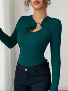 Detail shot of the unique asymmetrical cut-out neckline with a gold ring ornament.