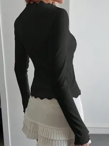 Detailed back view of a slim black ribbed long-sleeved top with delicate lace trim detailing