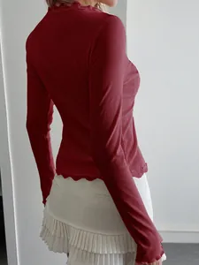 Detailed side view of a burgundy rib-knit long sleeve top featuring delicate lace trim