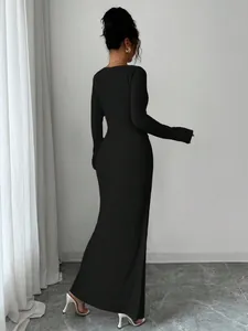 Detailed back view of a long-sleeved black maxi dress featuring ribbed knit fabric texture.