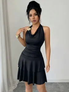 Vista detallada de un elegante vestido negro de cuello halter con una hebilla metálica dorada.