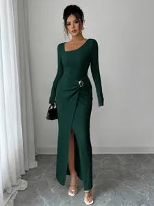 Close-up of dark green textured knit maxi dress with asymmetric neckline and buckle detail