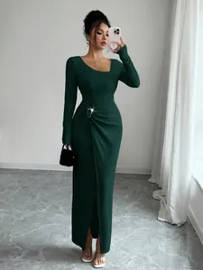 Detailed view of a dark green textured knit maxi dress with an irregular neckline.