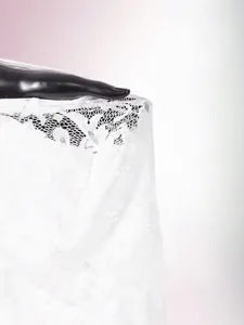 Detail shot of intricate white floral lace mesh fabric for a sexy slim-fit dress