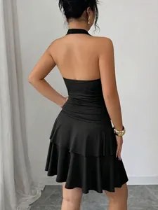 Elegante vista trasera de un vestido halter negro fruncido con falda de volantes