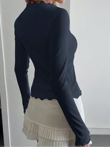 Detailed side view of navy ribbed long sleeve top with delicate lace trim on hem and collar