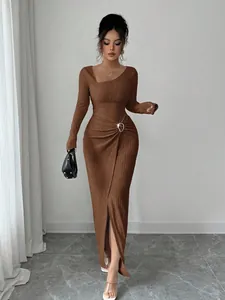 Elegant brown textured knit long dress with asymmetrical neckline and waist buckle detail.