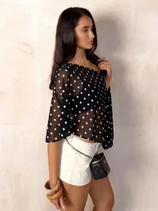 Detail eines schicken schwarzen Chiffon-Oberteils mit Polka-Dots für einen Sommer-Look.