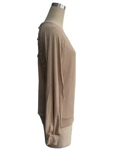 Side view of beige ribbed knit top featuring delicate lace patchwork on the back.