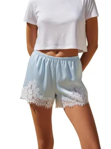 Women's light blue satin loungewear shorts with white lace trim and elastic waist