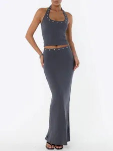 Detail shot of charcoal halter crop top and maxi skirt set with metal eyelet accents
