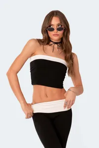 Model wearing black and white slim-fit low-waisted flared pants in a studio setting