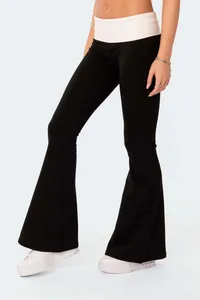 Detail view of black low waist flare pants with white fold-over waistband for women.